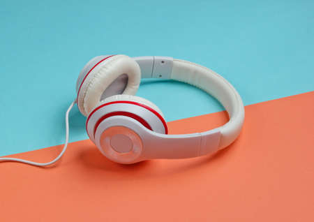 Classic white wired headphones on colored paper background. Retro style. 80s. Pop culture. Minimal Music Conceptの写真素材