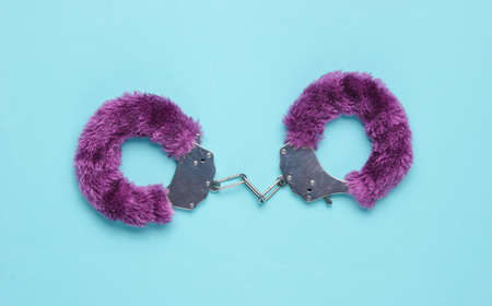 Handcuffs for sex games on blue background. Sexual bdsm toy. Love concept.の写真素材