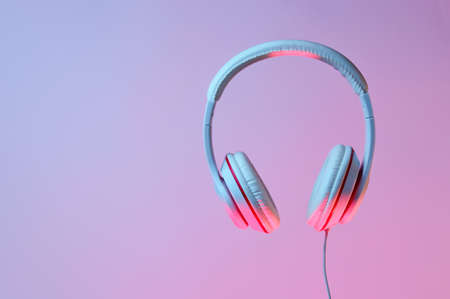 Classic wired headphones with gradient blue pink neon light. Retro style.Retro wave. 80s. Minimalistic music concept.の写真素材