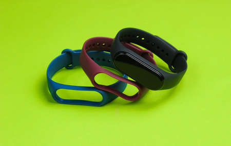 Smart watch with interchangeable bracelets on green background. Fitness tracker. Modern gadgetsの写真素材