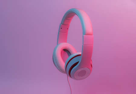 Classic wired headphones with gradient blue pink neon light. Retro style.Retro wave. 80s. Minimalistic music concept.の写真素材