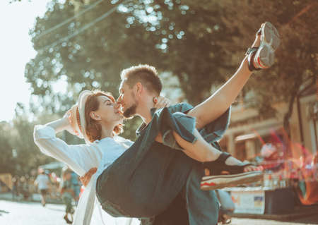 Cheerful cheerful hipster couple in love kissing in a city street. The romantic concept of lovers. love storyの写真素材