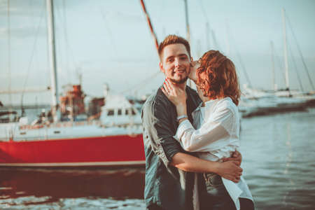 Romantic concept. Young couple in love at sea on a background of yachts club. Youth lovestory