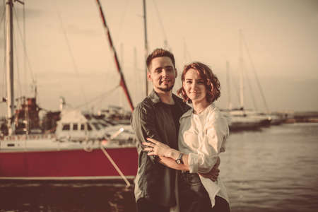 Romantic concept. Young couple in love at sea on a background of yachts club. Youth lovestoryの写真素材