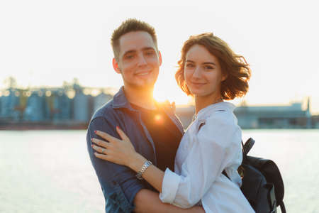 Portrait of a young smiling couple of lovers at sunset on the seaの写真素材