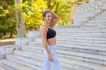 Healthy lifestyle concept. Portrait of young sport woman dressed in sport clothes outdoorsの写真素材