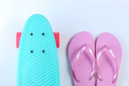 Flip flops and plastic mini cruiser board on white background. Summertime fun. Top viewの写真素材