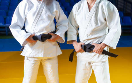 Two masters of sports in judo in a white kimano with a black belt. Crop photoの写真素材