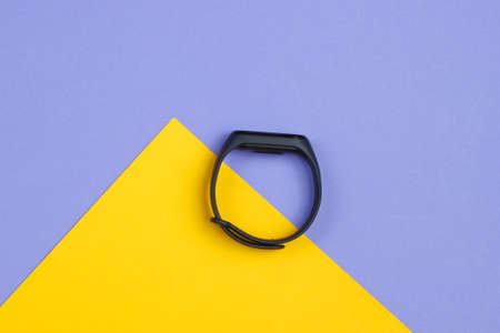 Smart bracelet on yellow purple background. Top viewの写真素材