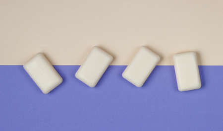 Pieces of soap on a colored paper background. Top view. Minimalistic fashion still life
