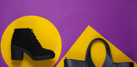Black suede boot on a purple paper background with yellow geometric shapes. Minimalistic fashion still life. Flat lay. Topの写真素材