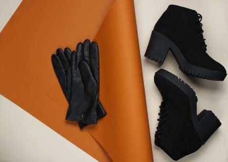 Leather gloves and boots on folded paper background. Minimalistic fashion still life. Flat lay. Top viewの写真素材