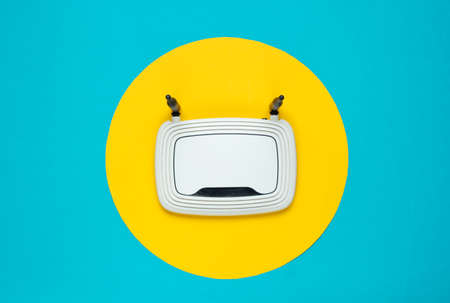 Wifi router on yellow background with yellow circle in the middle. Top view. Minimalism