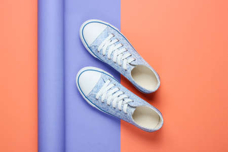 Sneakers on wrapped paper background. Color trend, minimalistic fashion still life. Top viewの写真素材