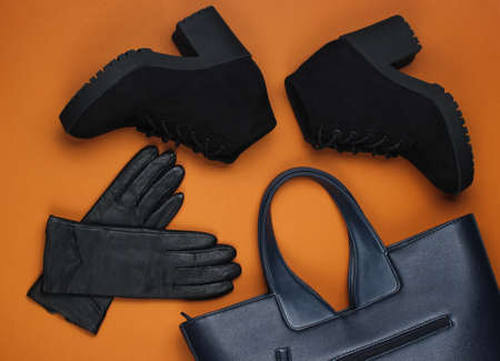 Leather bag, gloves and boots on brown paper background. Minimalistic fashion still life. Flat lay. Top viewの写真素材