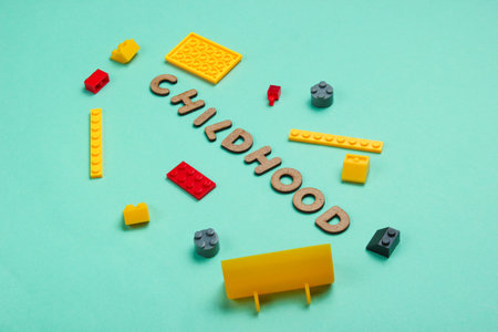 Childhood concept. Toy bricks on blue paper background. Top view