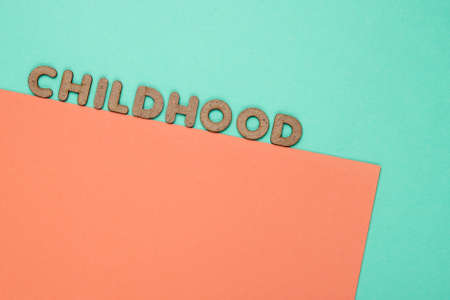 Childhood word on blue-pink paper background. Top viewの写真素材