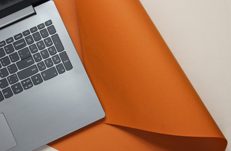 Laptop on a colored paper background. Studio shot, top view