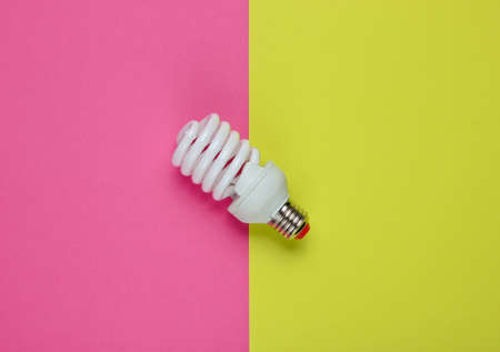 Spiral eco light bulb on a colored paper background. Top view. Minimalistic still lifeの写真素材