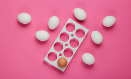 Empty tray and chicken eggs on pink background. Minimalism food concept. Top view