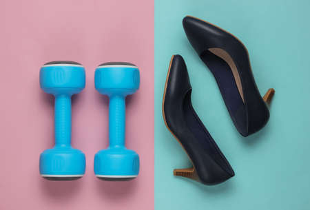 Leddy's sport. Women's high heel shoes with dumbbells on pastel background. Fitness and fashion...