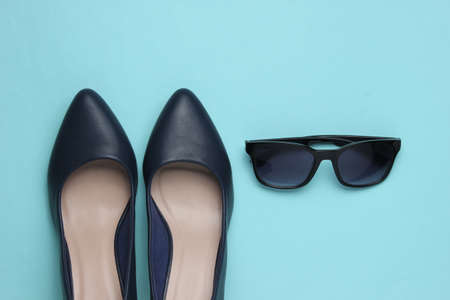 Stylish female look. Leather high heel shoes and sunglasses on a blue background. Top viewの写真素材
