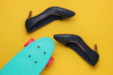 Summer fun. Women's high heel shoes with cruiser board on yellow studio background. Fashion shot, top viewの写真素材