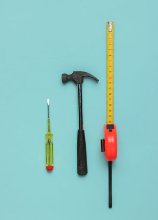 Hammer, screwdriver and ruler on blue background. Top view, minimalismの写真素材