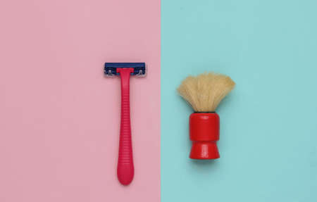 Razor, shaving brush on a pastel pink-blue background. Top viewの写真素材