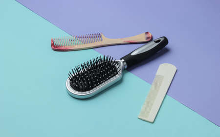 Combs on blue-purple pastel background. Beauty minimalistic concept. Hair care. Top viewの写真素材