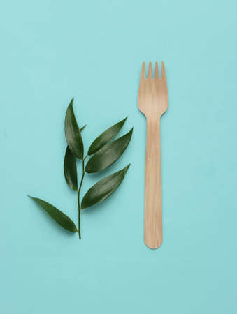 Eco food concept. Wooden forks, green leaves on blue pastel background. Top view.の写真素材