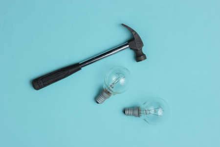 Hammer and old light bulbs on a blue background. Top viewの写真素材
