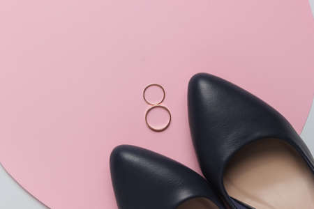 Bride shoes, golden wedding rings on pink pastel background. Top viewの写真素材