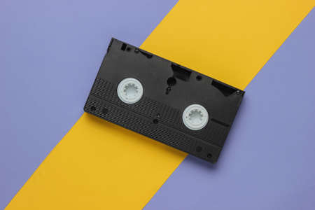 Retro video cassette on a yellow-purple background. 80s. Top viewの写真素材