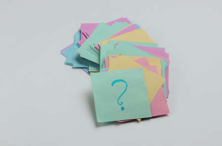 Minimalistic office concept. Lot of memo papers with question mark on white background. Top viewの写真素材