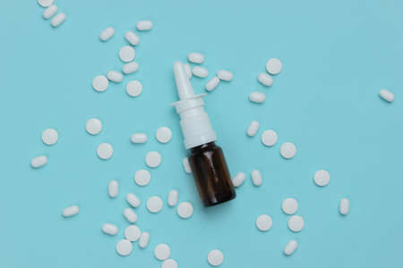 Cold treatment. Nasal spray with pills on a blue background. Top viewの写真素材