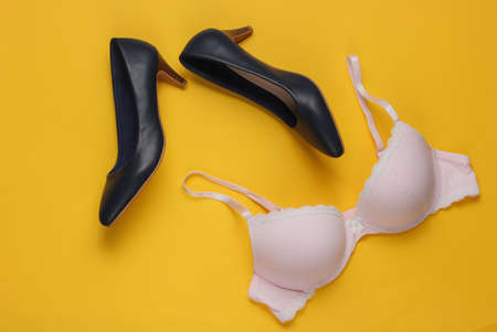 Underwear bra, high heel shoes on yellow background. Overhead view of woman's casual outfit. Trendy women clothes. Flat lay, top view.の写真素材