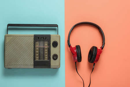 FM radio receiver, retro style wired headphones on pink blue background. Music lover concept. Top view. 70sの写真素材