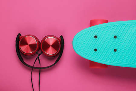 Cruiser board, headphones on pink background. Summer fun. Retro style. 80s. Top viewの写真素材
