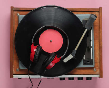 Old-fashioned vinyl player, headphones on pink pastel background. Media 70s.の写真素材