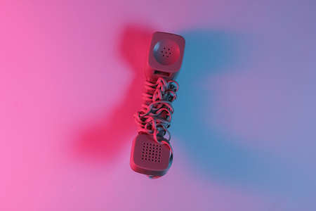 Old fashioned handset. Red-blue neon gradient light. Retro wave, pop culture. Top viewの写真素材
