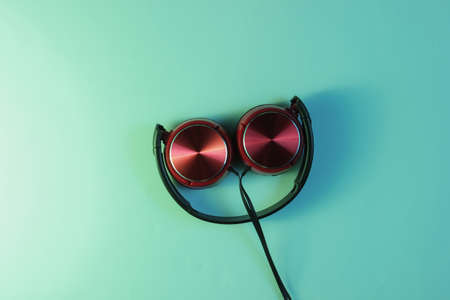 Wired headphones. Holographic gradient light. Retro wave, 80s pop culture. Top viewの写真素材