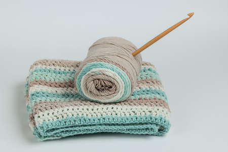 Yarn with skeins of woolen threads and wooden crochet for knitting on white background.の写真素材