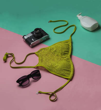 Summer background. Woman's swimsuit and beach accessories on pink blue background. Overhead view of woman's swimwear. Vacation on the beach. Flat lay, top view.の写真素材