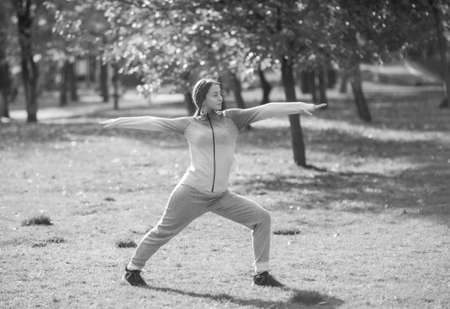 Young sport woman practicing yoga asana exercises in autumn parkの写真素材