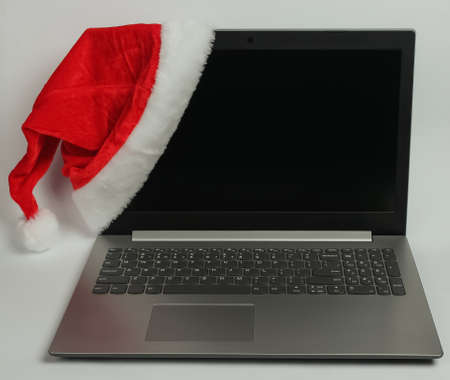 Laptop with santa hat on white background.の写真素材