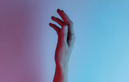 Female hand. mystical concept. Creative pop art pink blue neon color. Trendy gradient illumination. Night lightの写真素材