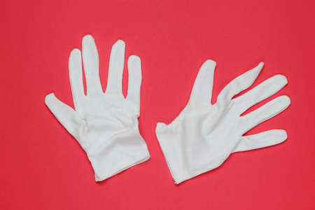 White waiter gloves on red background. Top viewの写真素材