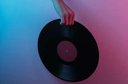 Retro wave 80s. Hand holding vinyl record. Creative pop art pink blue neon color. Trendy gradient...