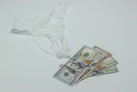The concept of prostitution. Women's sexy panties, hundred dollar bills on a white backgroundの写真素材